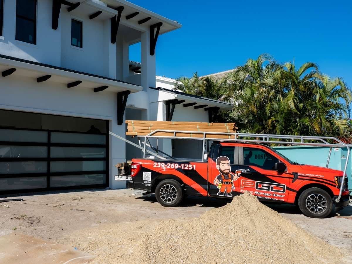 Prime Garage Door installation truck in front of a newly installed residential garage door in Naples, Florida