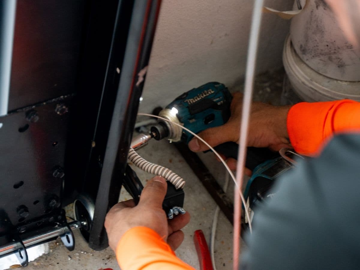 Prime Garage Door technician repairing a residential garage door opener