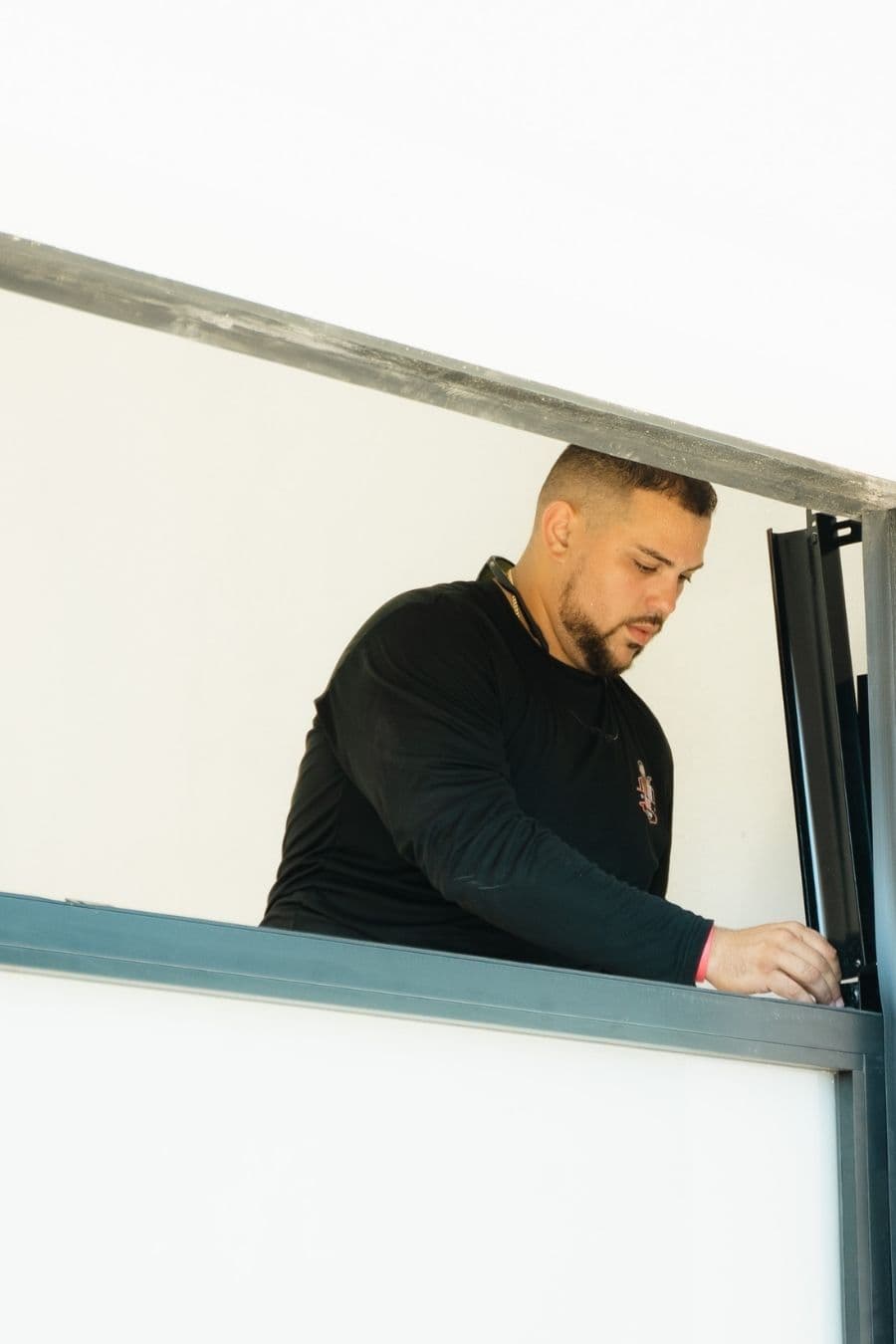 Prime Garage Door technician repairing a residential garage door in Naples, Florida