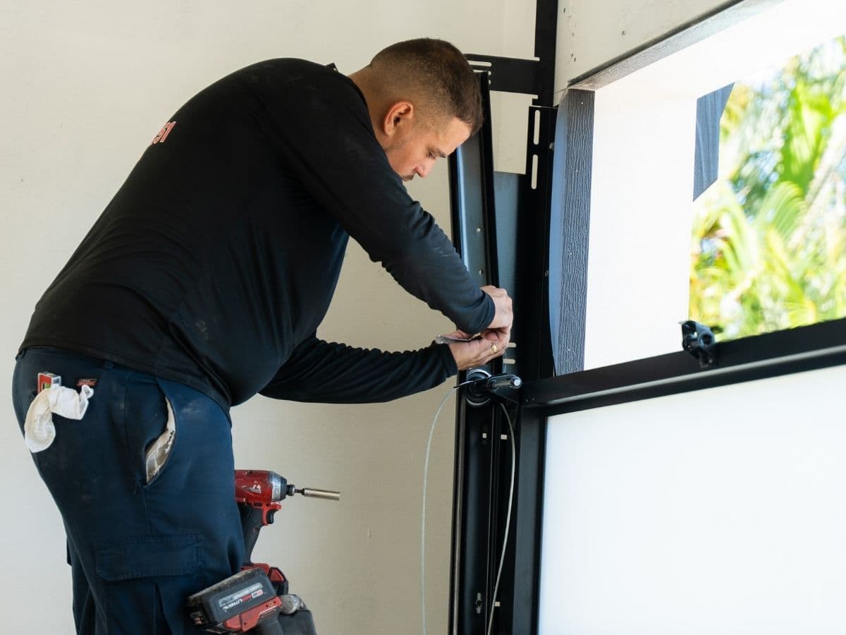 Professional garage door repair technician repairing a residential garage door in Southwest Florida
